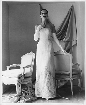 black and white photograph of model wearing a white evening gown by Galanos