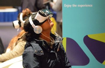 A woman wearing headphones and virtual reality goggles