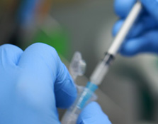 A syringe suctioning out of a vial