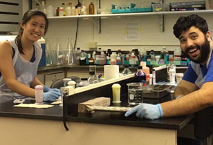 Two students sitting at a lab bench smiling