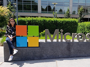 Woman sitting next to Microsoft sign