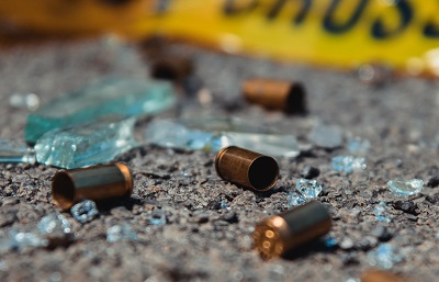 Bullets on Pavement With Broken Glass